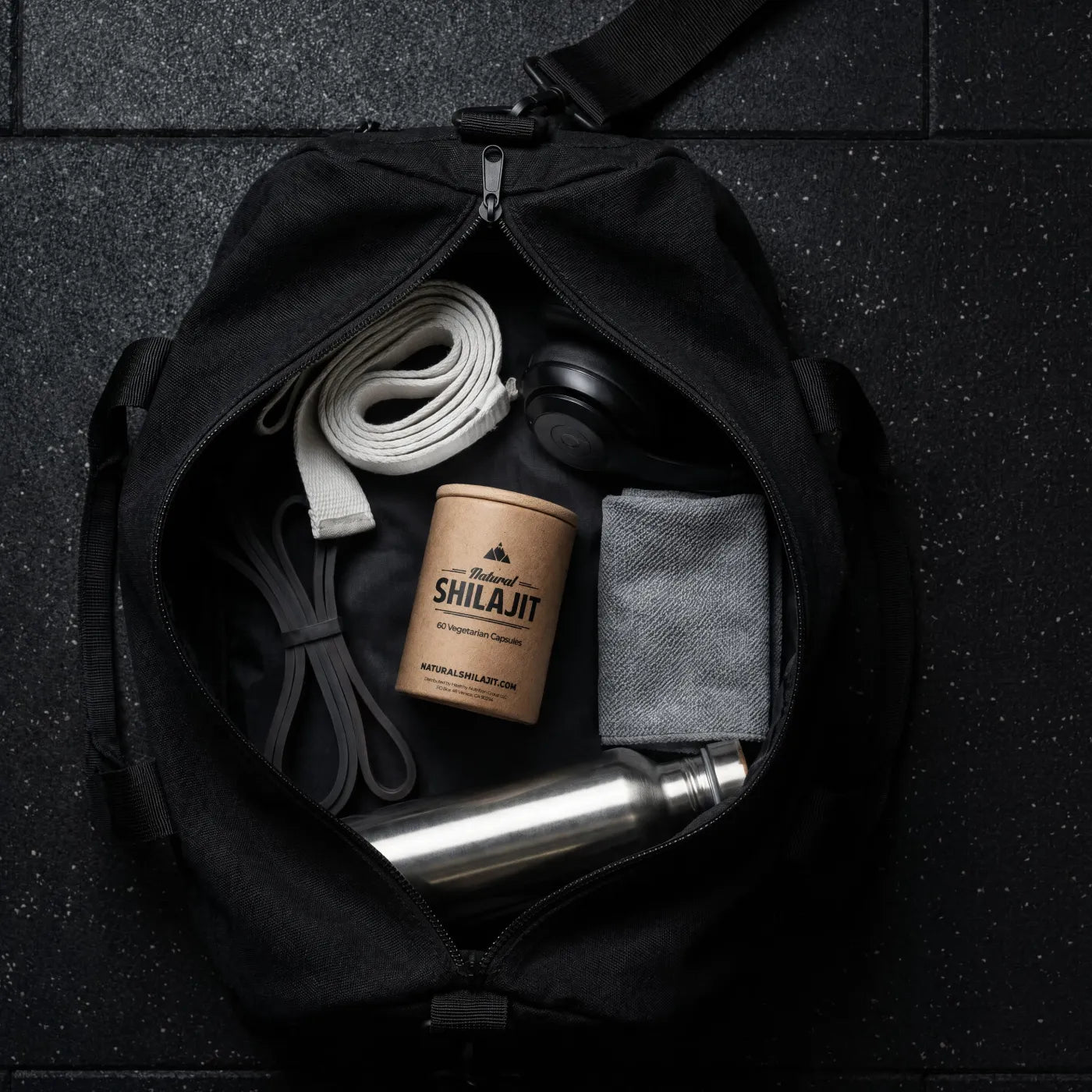 Shilajit capsules packed in a gym bag with towel, bands and water bottle