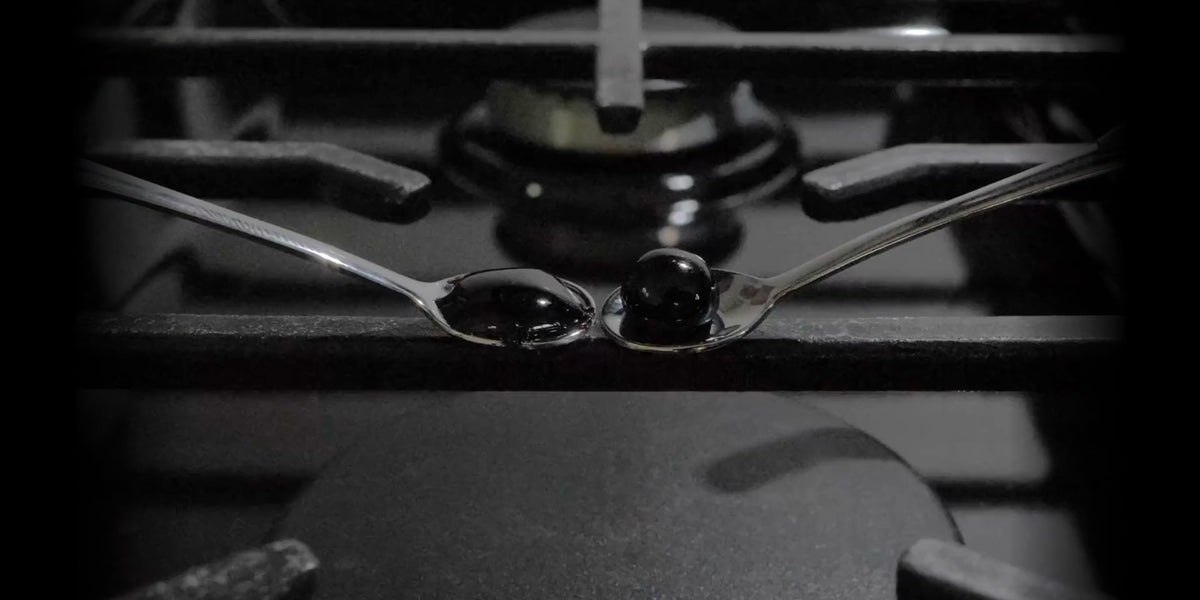 Side-by-side fire test: a lab-made copy foams and expands on the left spoon while real Altai resin chars gradually on the right